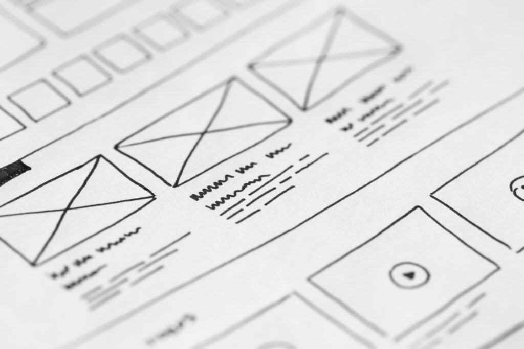 Detailed close-up of a hand-drawn wireframe design on paper for a UX project.